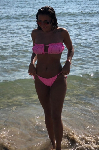 Alexandra stood in the sea wearing a pink bikini